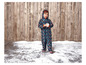 Un enfant dans une combinaison de neige bleue à motif arc-en-ciel tient une boule de neige.