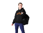 Femme en sweat à capuche noir avec logo orange, leggings bleus et sac de sport noir.
