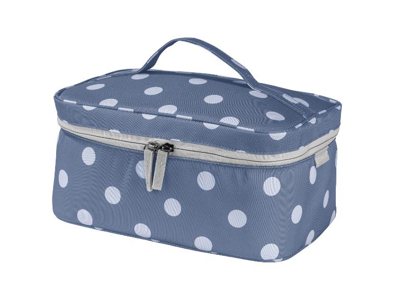 Une trousse de toilette bleue à pois blancs avec une fermeture éclair.