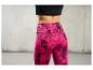 Femme portant un legging rose avec un motif géométrique noir.