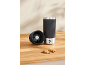 Mug isotherme noir avec couvercle et biscuits sur une table en bois