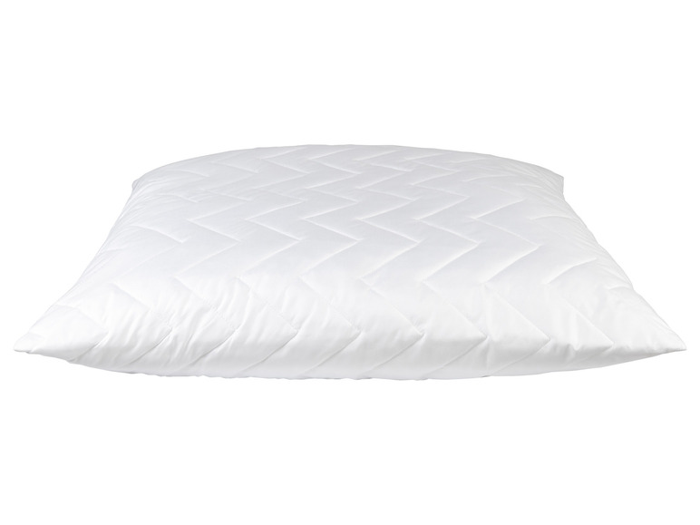 Un oreiller blanc avec un motif matelassé.