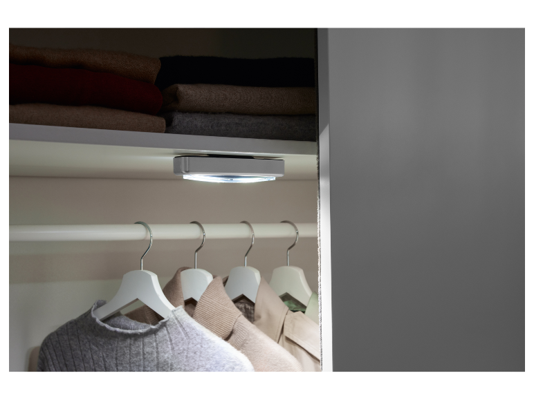 Éclairage LED pour placard, fixé au plafond, éclairant les vêtements suspendus.