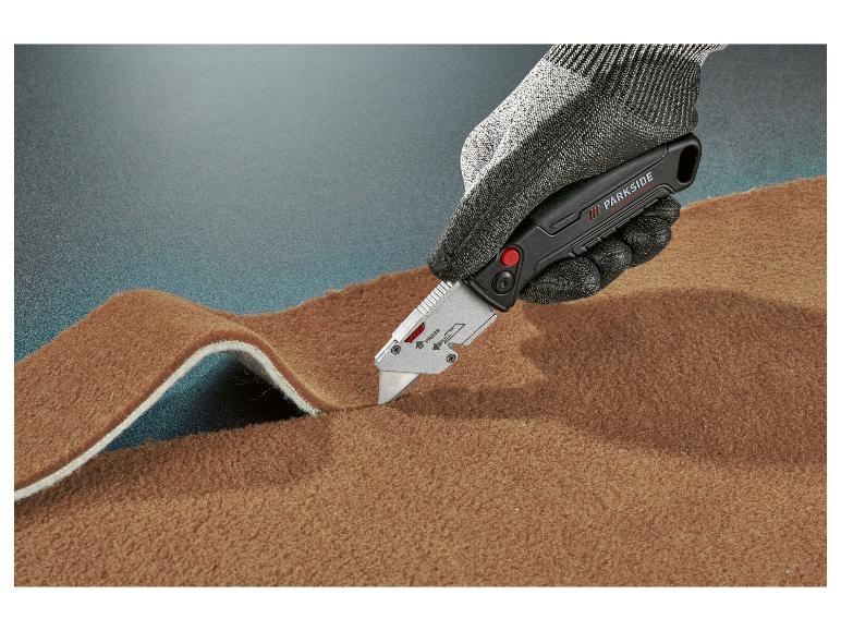 Un couteau Parkside Performance coupe un tapis marron.
