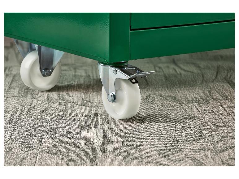 Roues blanches sur une unité de rangement verte, sur un tapis gris