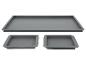 Trois moules en silicone gris : un rectangulaire et deux carrés.