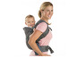 Une femme porte un bébé dans un porte-bébé.