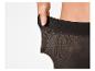 Gros plan d'une main étirant la ceinture d'un collant noir, montrant son élasticité.