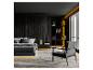Chambre moderne sombre avec lit, fauteuil et bibliothèque avec éclairage décoratif.