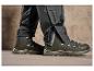 Pantalon de randonnée noir avec des détails imperméables et des chaussures de randonnée noires.