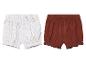 Deux shorts bébé: un imprimé floral blanc et or, un brun rouille uni.