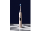 Brosse à dents électrique dorée avec tête bleue et verte, affichant 'Clean' sur l'écran.
