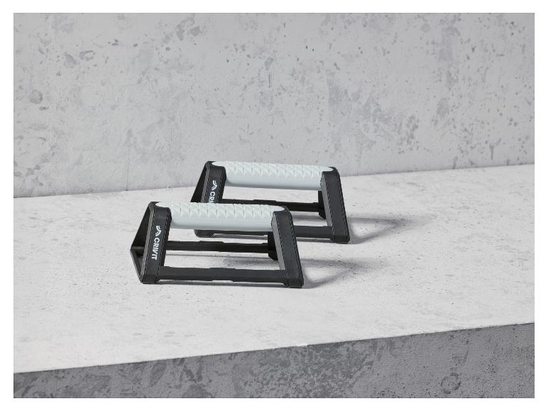 Deux barres de pompes Crivit noires sur une surface en béton.