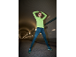 Femme en haut de sport vert citron et leggings bleu foncé s'étirant dans un tunnel.