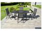 Ensemble de mobilier de jardin: table grise et quatre chaises sur une terrasse en bois avec jardin.