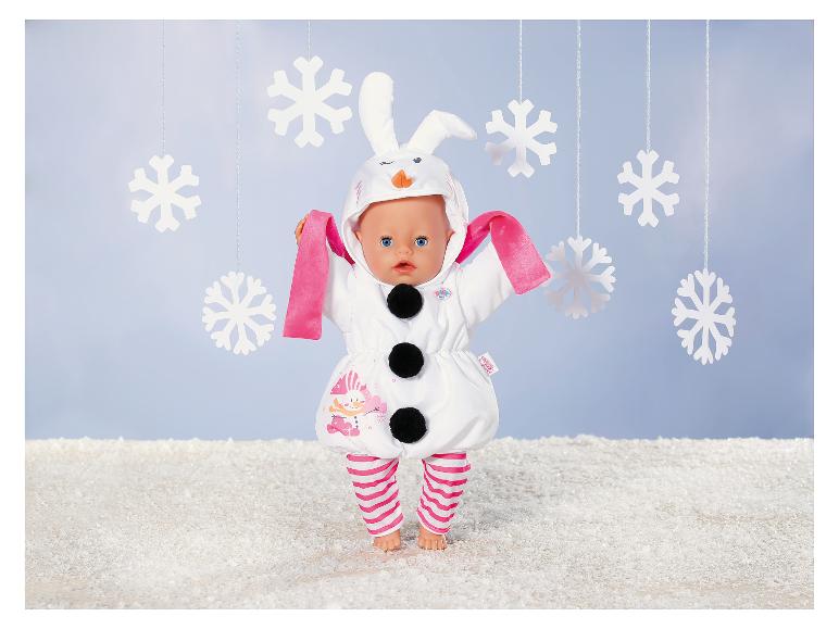 Poupée BABY born en costume de bonhomme de neige avec oreilles de lapin, entourée de flocons de neige.