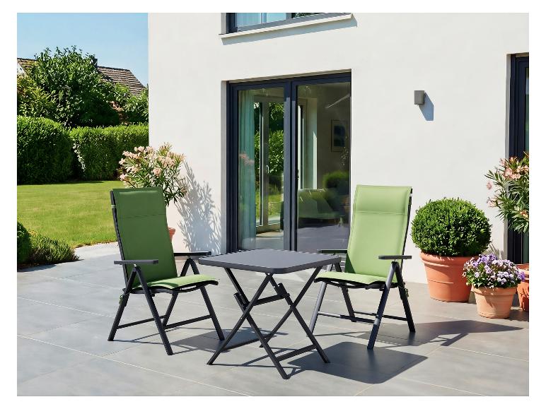 Chaises de jardin vertes et table assortie sur une terrasse.