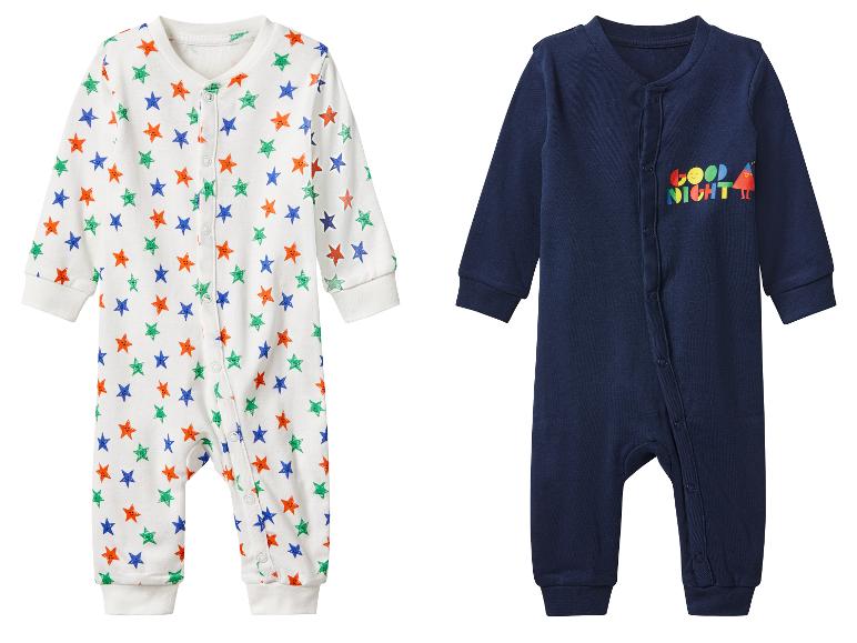 Deux pyjamas bébé, un à motifs étoiles et l'autre avec l'inscription 'Bonne nuit'.