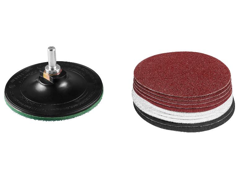 Un support de disque de ponçage avec un axe métallique et une pile de disques de ponçage variés.