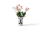 Vase noir et blanc avec des fleurs roses et des feuilles vertes