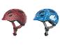 Deux casques pour enfants, un à motifs cœurs et l'autre à motifs requins.