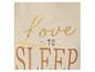 Gros plan d'un haut crème avec un imprimé doré et marron indiquant « Love to Sleep ».