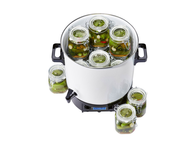 Une marmite à confiture électrique avec des bocaux en verre remplis de cornichons.