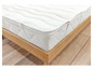 Un matelas blanc avec un cadre en bois sur un sol en bois.