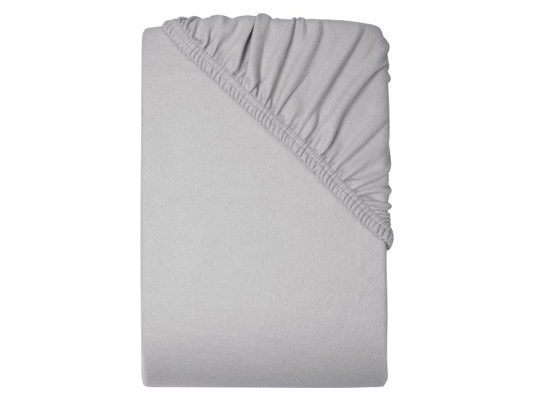 Drap-housse gris plié sur fond blanc.