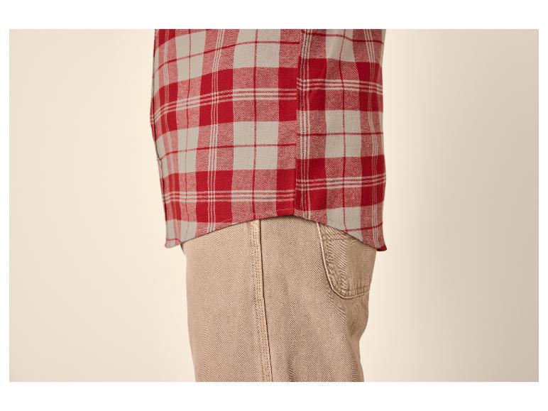 Chemise à carreaux rouges et beiges avec un pantalon beige.