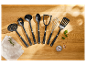 Ustensiles de cuisine Silit en silicone noir sur une table en bois.