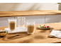 Deux verres de café avec des macarons et du sucre sur une table en bois.