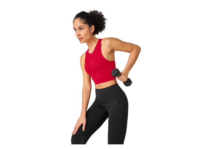 Femme faisant du sport avec des leggings et un haut de sport, haltères à la main.