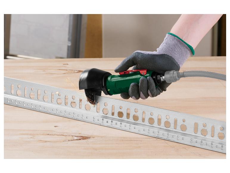 Main gantée utilisant une meuleuse d'angle pour couper un profilé métallique sur un établi en bois.