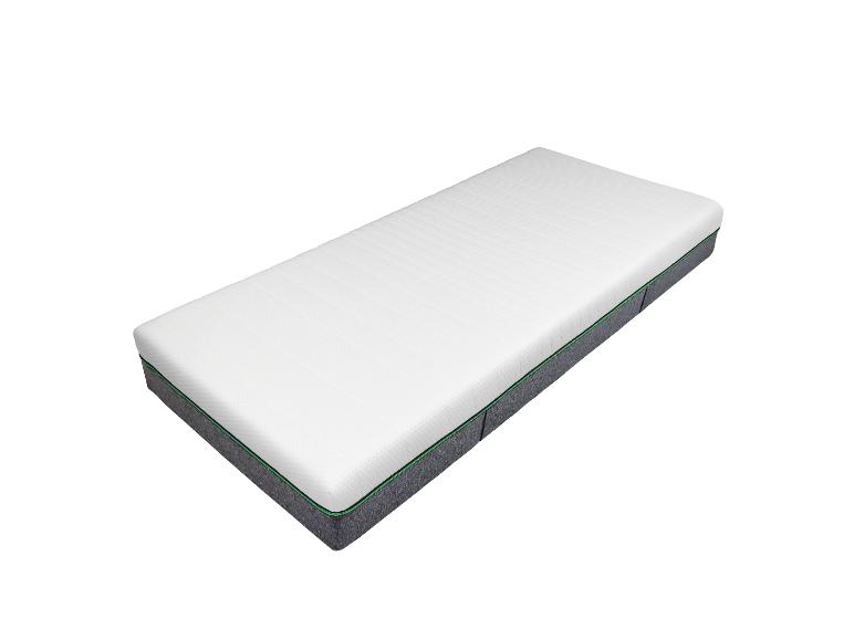 Un matelas blanc avec un bord gris et vert.