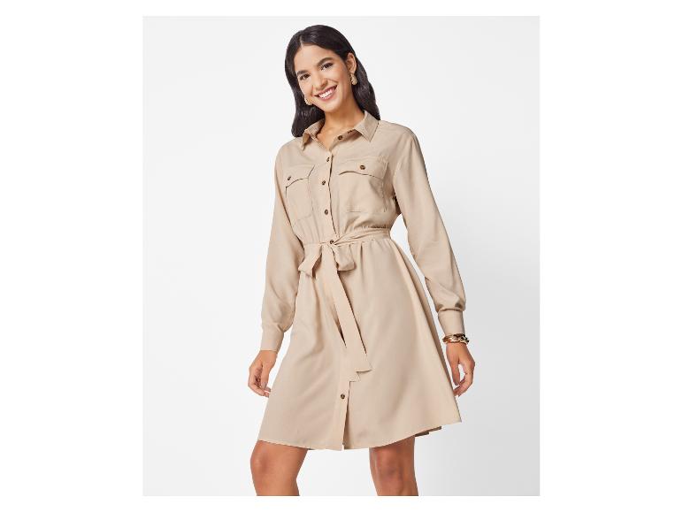 Robe chemise beige clair avec ceinture, portée par une femme souriante.