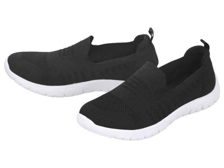 Chaussures de sport slip-on noires et légères avec semelles blanches.