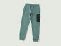 Un pantalon de survêtement vert avec une poche latérale.