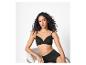 Femme en soutien-gorge et culotte noirs assise sur une chaise.