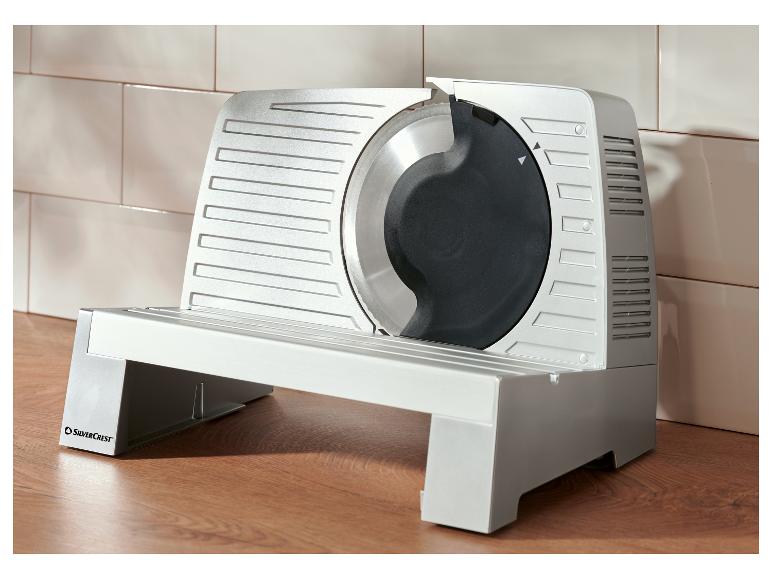 Trancheuse à viande SilverCrest sur un comptoir en bois devant un mur carrelé