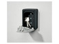 Un coffre à clés noir avec des clés à l'intérieur, fixé à un mur blanc.