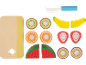 Planche à découper en bois, couteau et divers fruits comme le kiwi, l'orange, la banane, la fraise, la pastèque et le fruit de la passion.
