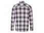 Une chemise à carreaux à manches longues en bleu marine, rouge et blanc.