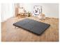 Ensemble de matelas de sol gris foncé dans une pièce lumineuse avec parquet.