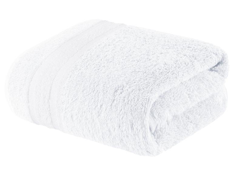 Une serviette blanche pliée sur un fond blanc.