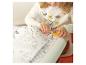 Enfant coloriant un livre de coloriage avec des dessins sur un rouleau de papier.