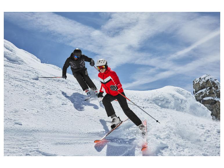 Deux skieurs en vestes et pantalons de ski, descendant une pente enneigée.