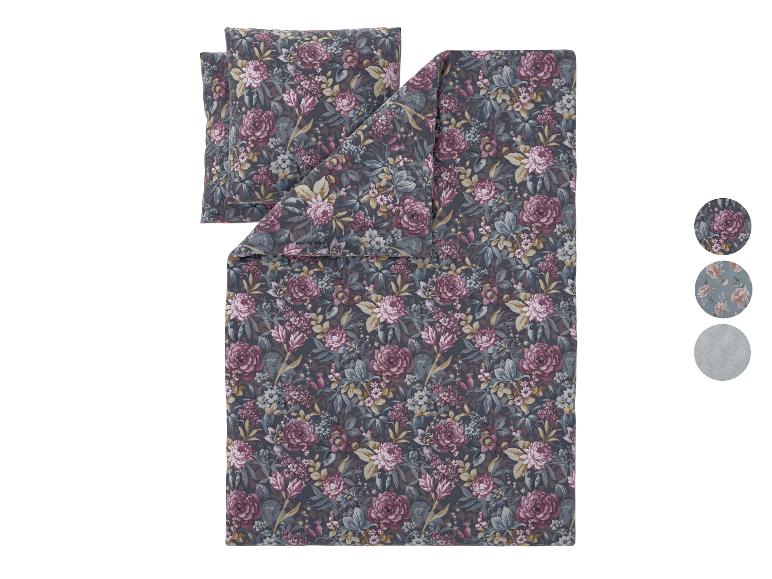 Parure de lit florale avec oreillers dans des tons gris foncé, rose et bleu.