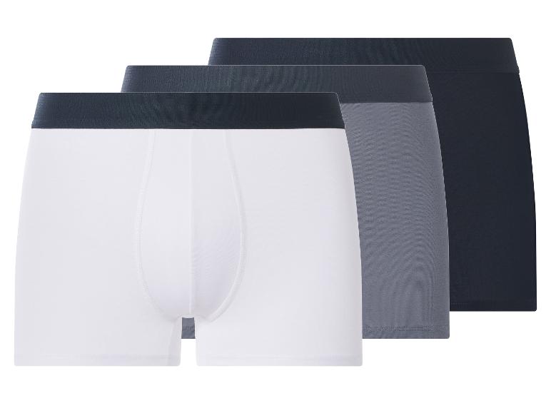 Lot de trois boxers pour hommes en blanc, gris et noir avec des ceintures foncées.