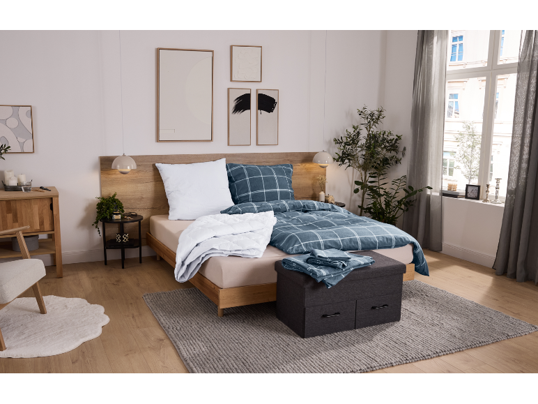 Chambre douillette avec lit en bois, parure de lit à carreaux bleus et tapis gris.